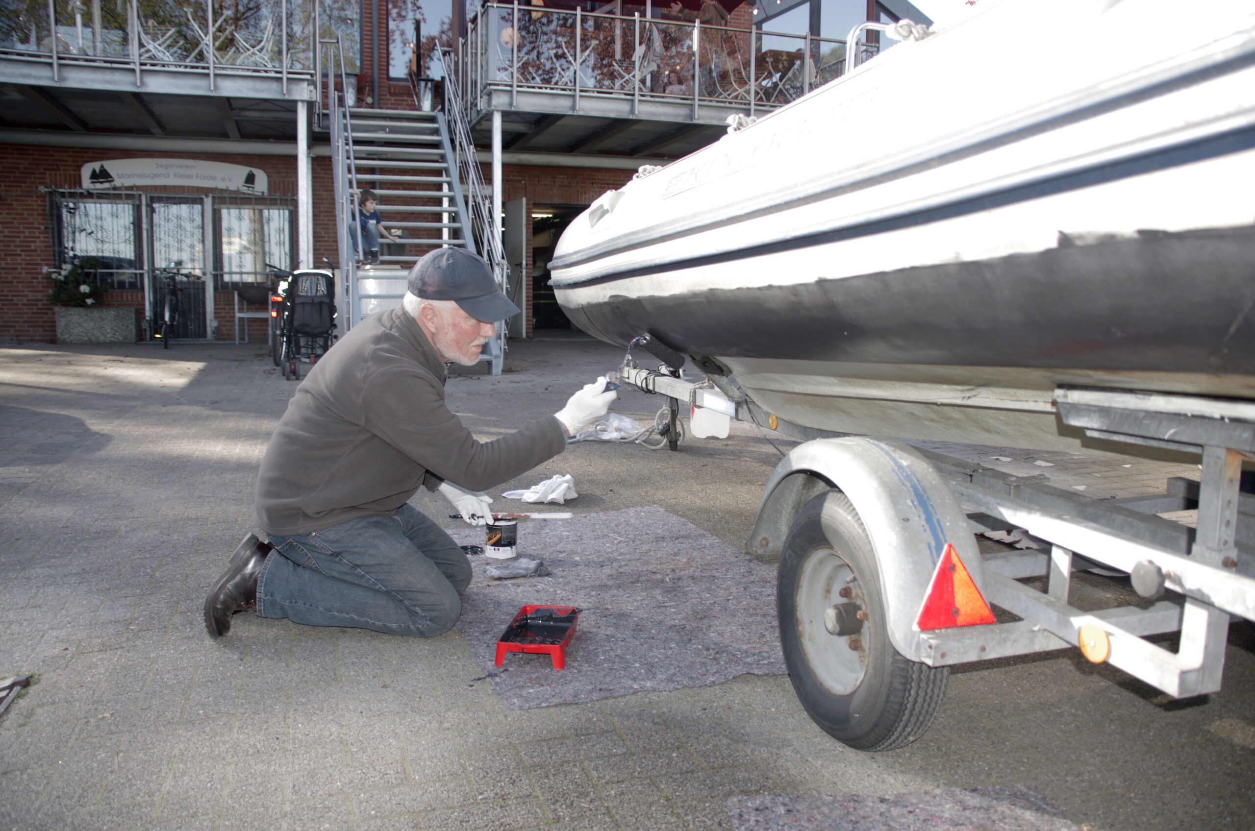 Dr. Dieter Hartwig trägt Antifouling beim großen Schlaufboot auf.